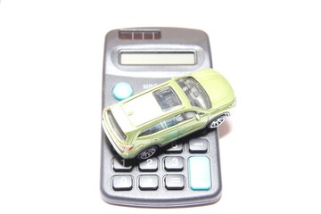 Toy car model with a calculator . Cost calculation, car purchase, fuel consumption, car service costs