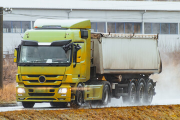 Side view of truck with semitrailer shipping goods on the highway. Sustainable future global supply chain. Export and import in the EU economic zone. Logistics and shipping concept.