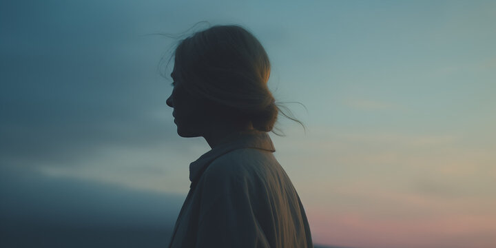 Contemplative blonde woman in silhouette, twilight hues casting a quiet mood