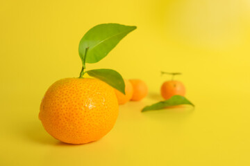Fresh and ripe oranges on a yellow background. Concept photo.
