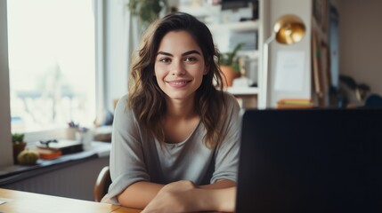 Beautiful GenZ woman working from home and smiling looking at the camera 