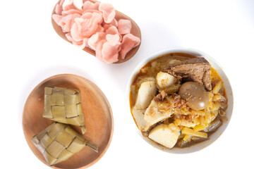 Ketupat Sayur or Lontong Sayur, a typical Indonesian food. Served with pumpkin vegetables, boiled eggs and tofu stew and crackers. Served during Ramadan, Eid al-Fitr and Adha. White Background