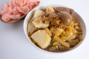 Ketupat Sayur or Lontong Sayur, a typical Indonesian food. Served with pumpkin vegetables, boiled eggs and tofu stew and crackers. Served during Ramadan, Eid al-Fitr and Adha. White Background