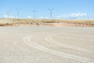 Traces of vehicle tracks on the clearing of a renewable energy zone, on the horizon in front of the...