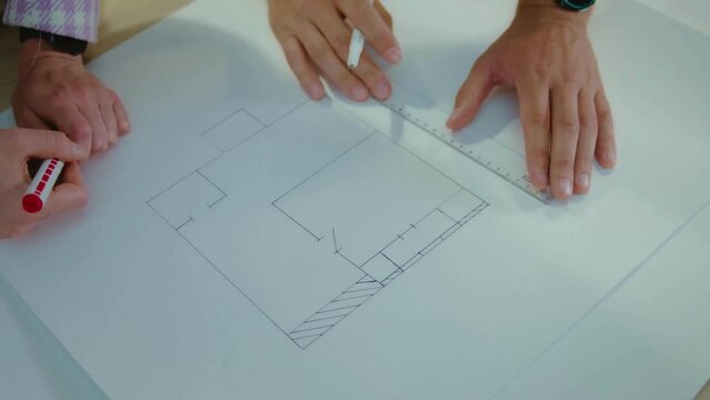 Closeup of hands architect team discussed about construction and architectural drawings works. view of architect drawing house plan on blueprint paper, architect sketching construction project.