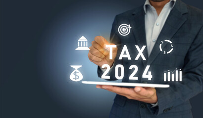 TAX 2024 and icons of money, bank, target, and graph on virtual screen. Business Man tapping on the screen having tablet.
