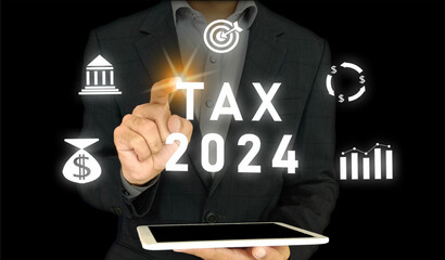 TAX 2024 and icons of money, bank, target, and graph on virtual screen. Business Man tapping on the...