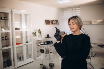  Master of permanent makeup with tool in hand in white office