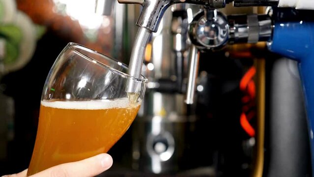 Close up shot of pouring beer into a glass with bubbles Pouring beer into