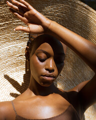 Portrait of an African woman in a large hat in the sun
