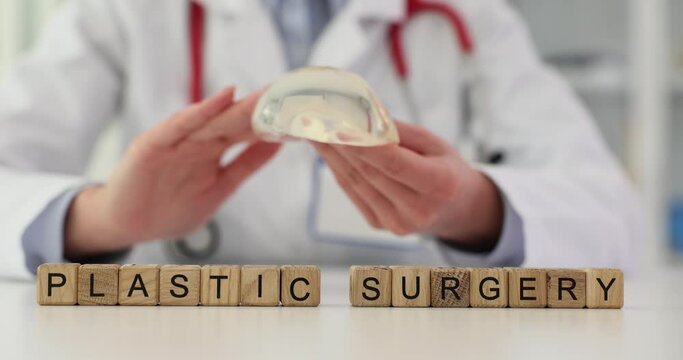 Plastic surgeon demonstrates properties of breast prosthesis