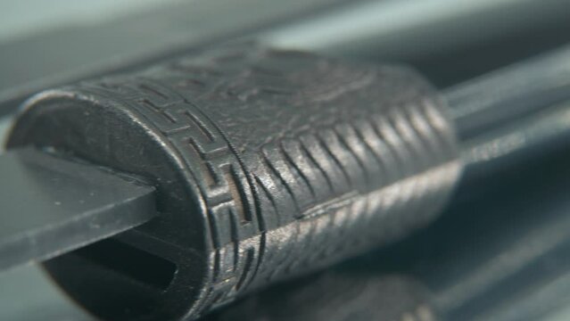 A macro close-up shot of two ancient silver knifes, Chinese antique weapon, historical vintage blade, old decorative steel, traditional dagger, professional lighting, cinematic 4K video pan right