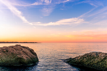 scenic sea shore view of island in ocean with waves and amazing cloudy sunset or sunrise on backgeound, vacation landscape of rocky beautiful isle