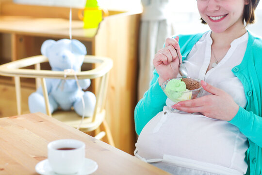 Pregnant woman with ice cream. Close up - Powered by Adobe