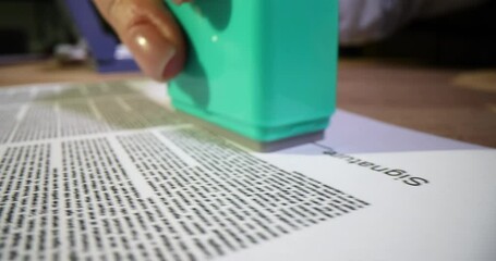 Agent female hands put approved stamp on document closeup