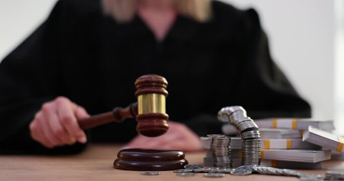 Judge knocks gavel with cash and coins and stacks of dollars on table