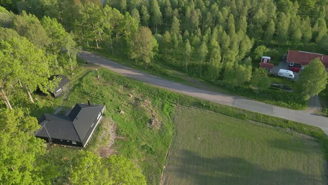 Cinematic aerial dolly tilt up reveals vacation home and stunning Illerasasjon Lake, Sweden at midday