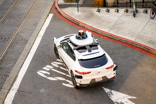 Waymo self-driving taxi drives down the street in San Francisco. 