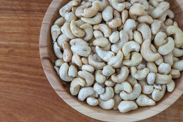 Cashews in a wooden bowl. Nuts are healthy food. Wooden background. Cashew kernel