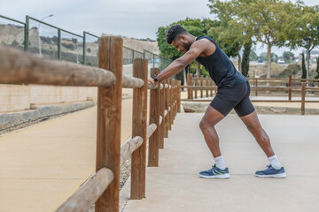 Determined black athlete warming up before workout