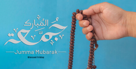 Jummah Mubarak blessed happy Friday Arabic Modern calligraphy, Selective focus image hand of Muslim...