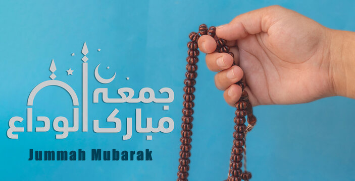 Jummah Mubarak blessed happy Friday Arabic Modern calligraphy, Selective focus image hand of Muslim woman holding prayer beads.