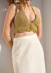 Unrecognizable caucasian young woman wearing hand made golden crochet top