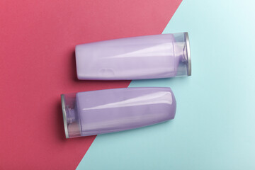 Shampoo bottles on blue pink background