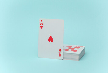 Ace of hearts and stack of playing cards on blue background