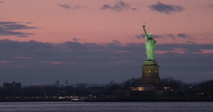 Statue of LIberty Towering Over Water of New York Bay After Sunset