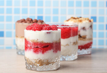 Homemade layered Desserts in a glass cups with yogurt, berries, cookie and chocolate balls on table
