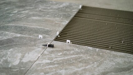 Laying tiles on the floor indoors. Ceramic tiles lie on the floor close-up. Laying floor tiles....