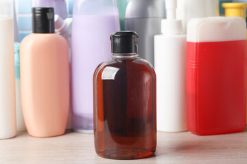 Many different shampoo and other cosmetic product bottles on a tile background