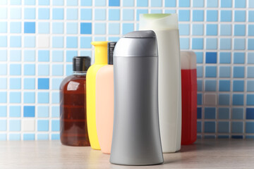Many different shampoo and other cosmetic product bottles on a tile background