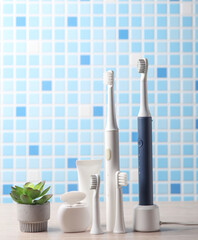Modern smart ultrasonic toothbrush with dental floss, heads and toothpaste on the table