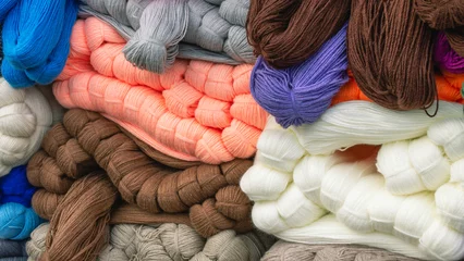 Fotobehang Wool yarn for knitting. Wombs of natural wool yarn for knitting warm clothes. Multicolored yarn in skeins. Making warm clothes for the cold season. © Eduard Belkin