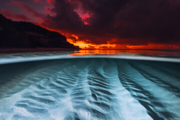 Split view with sunset and underwater sandy sea bottom. Tropical seascape with colorful bright...