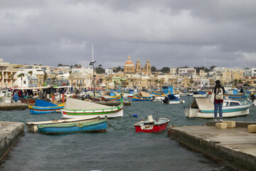 Fototapeta na wymiar Colorful typical boats in traditional fisherman village Marsaxlokk, Malta
