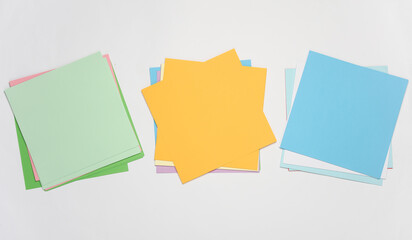 Square sheets of colored paper for origami creativity on white background