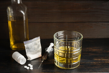 Alcohol drink in a glass, white pills, syringe with drug substance, heroin dose, narcotics powder...