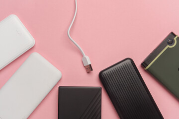 Power banks and external hard drives on a pink background