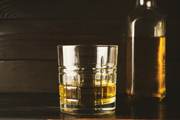 Glass with alcoholic drink, whiskey, brandy, rum on a wooden table