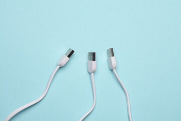 Three white USB cables on a blue background