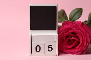 White Wooden calendar mockup with date 05 without month on pink background with flowers