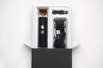 New beard trimmer in packaging with accessories on a white background - obrazy, fototapety, plakaty