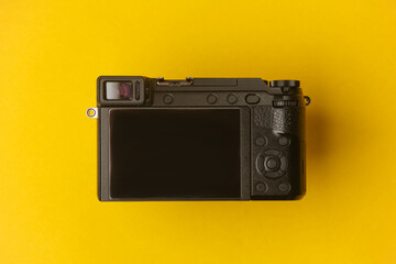 Modern mirrorless camera with blank screen on a yellow background
