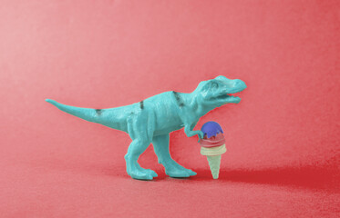 Toy dinosaur tyrannosaurus rex with ice cream on red background. Minimalism creative layout