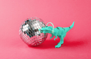 Toy dinosaur tyrannosaurus rex with disco ball on red background. Minimalism creative layout