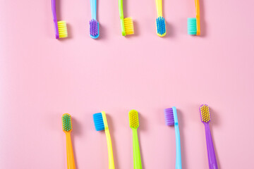 A bright composition of toothbrushes of different colors. Bright background with toothbrushes, free space for text or logo.