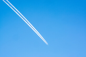 A white footprint on the blue sky, a footprint from the flight of a passenger plane.